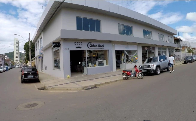 Prédio de esquina com a placa Ótica Real visto da rua